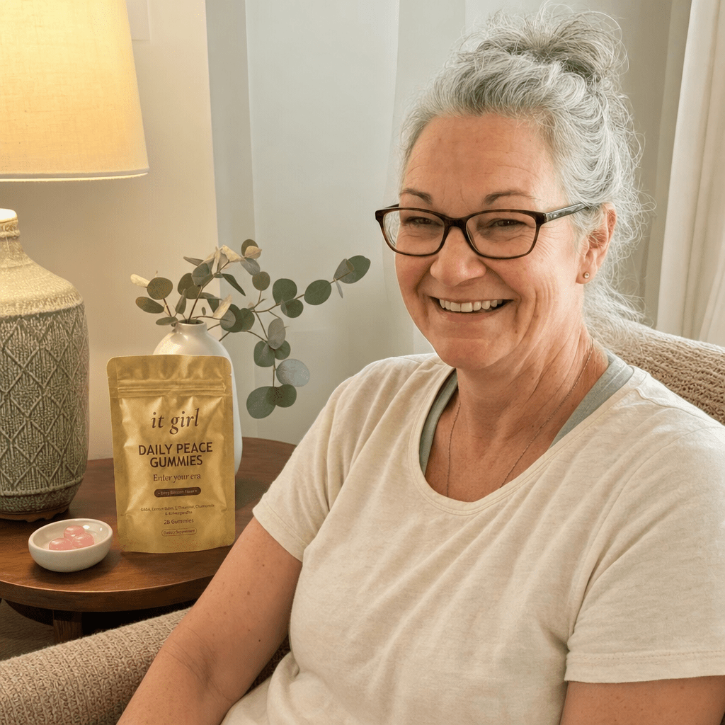Woman about sixty in soft evening light, shoulders dropping, a relieved exhale, the Daily Peace pouch resting beside her, the off-switch flipping