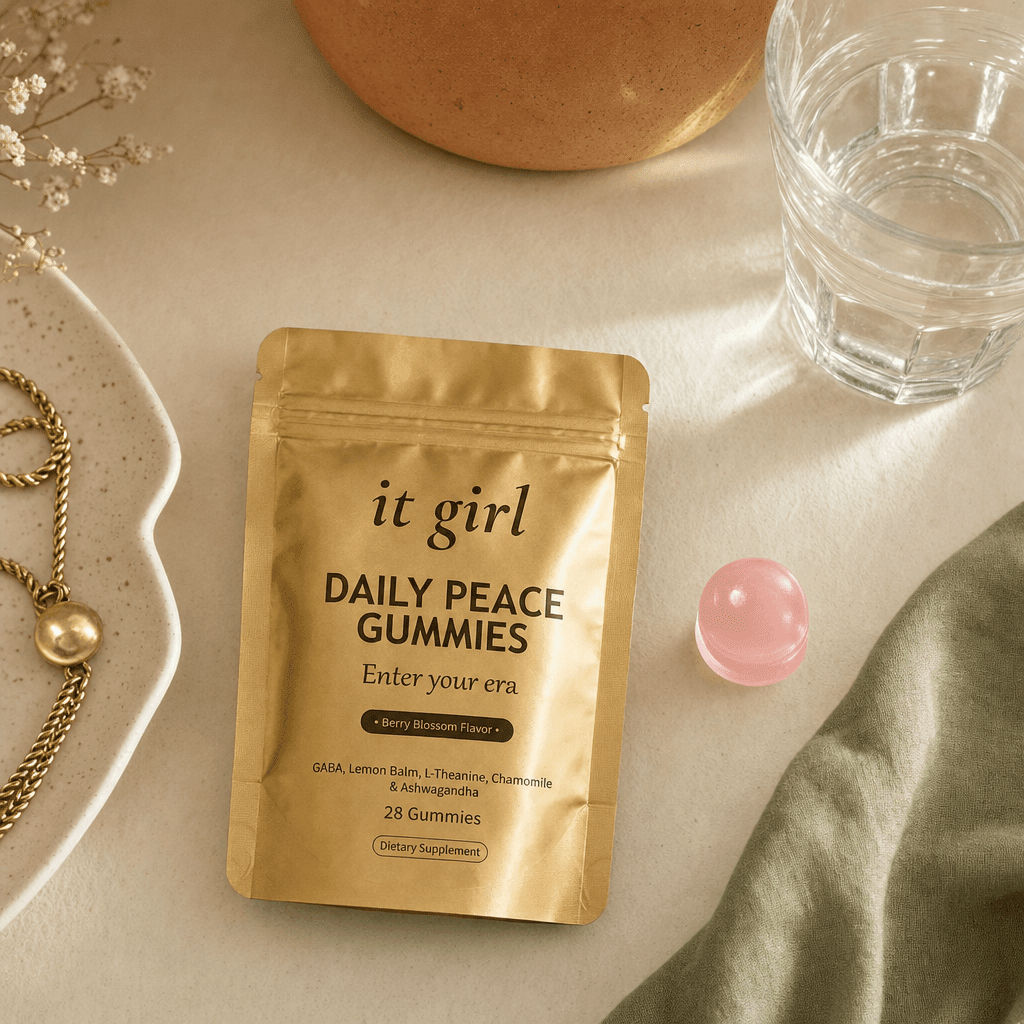 Open palm holding a single pink Daily Peace gummy beside the gold pouch and a glass of water on a cream counter, the GABA and L-Theanine calm signal handed back