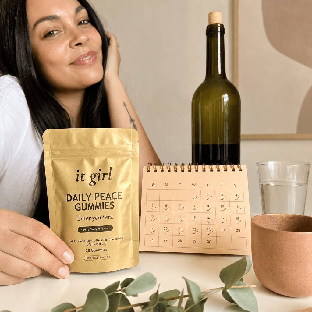 The palm-sized gold It Girl Daily Peace pouch and a month calendar beside one bottle of wine, a whole month of calm for less than one bottle
