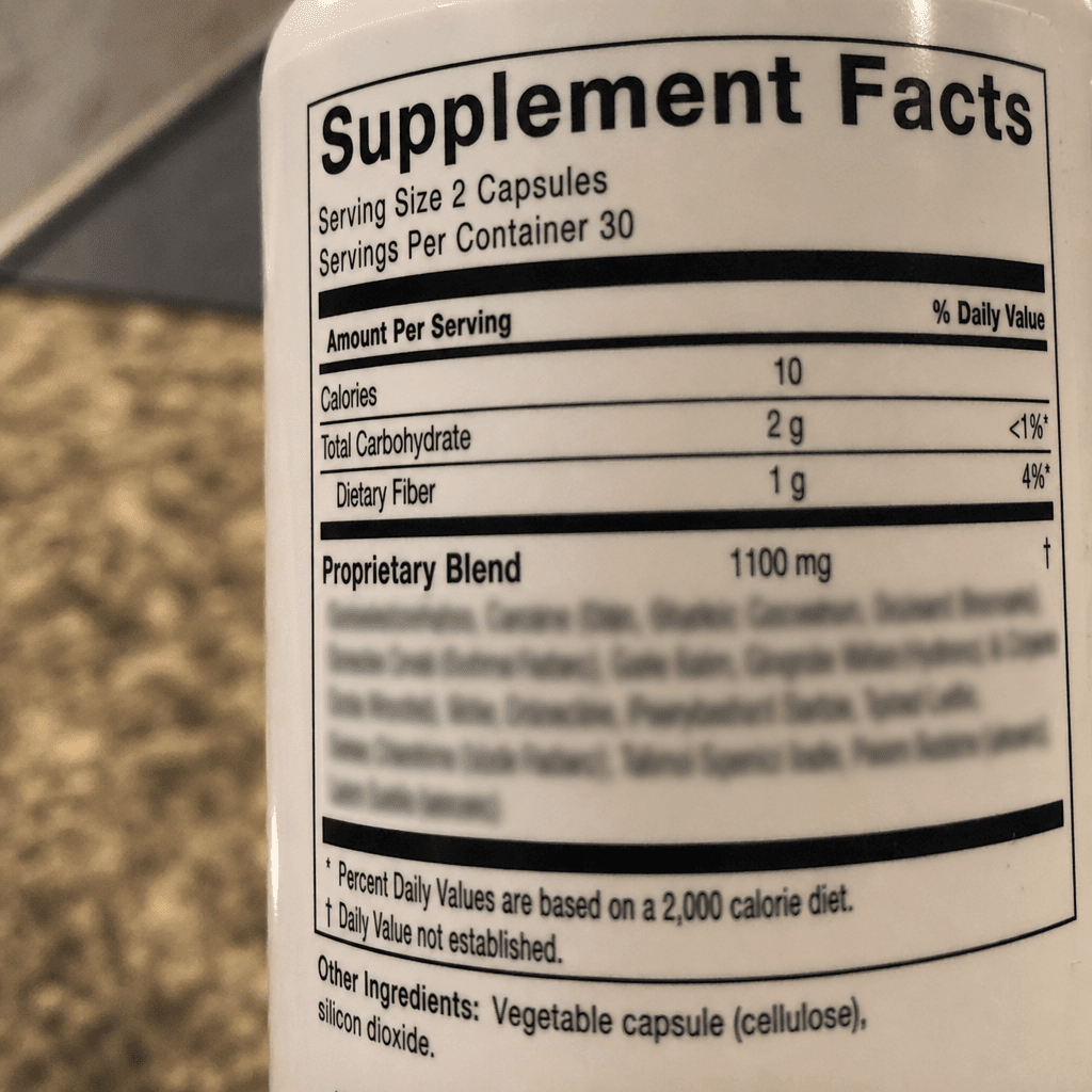 Tight iPhone-style macro photo of a plain generic supplement bottle's Supplement Facts panel zoomed in hard on the line that reads Proprietary Blend, the individual milligrams beneath it naturally too small to read, no hands, no It Girl product